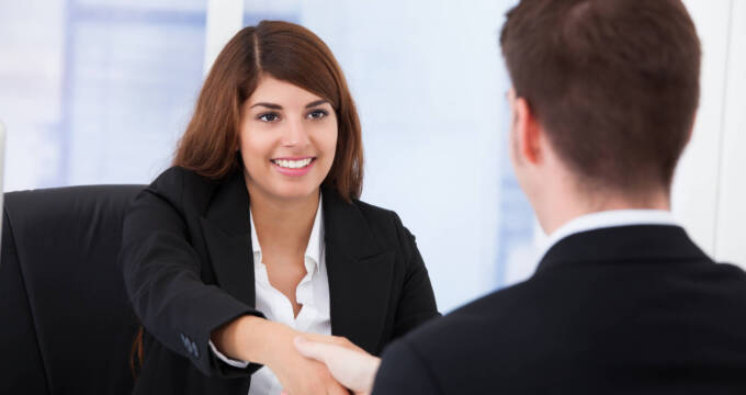 woman shaking hand of man in meeting